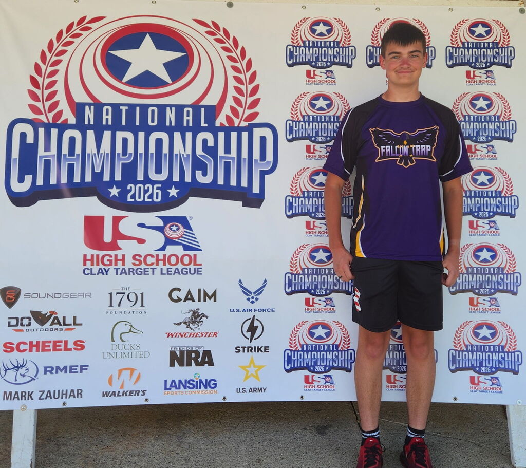 SFHS Student standing in front of the USA Clay Target League National Championship 2026 Banner