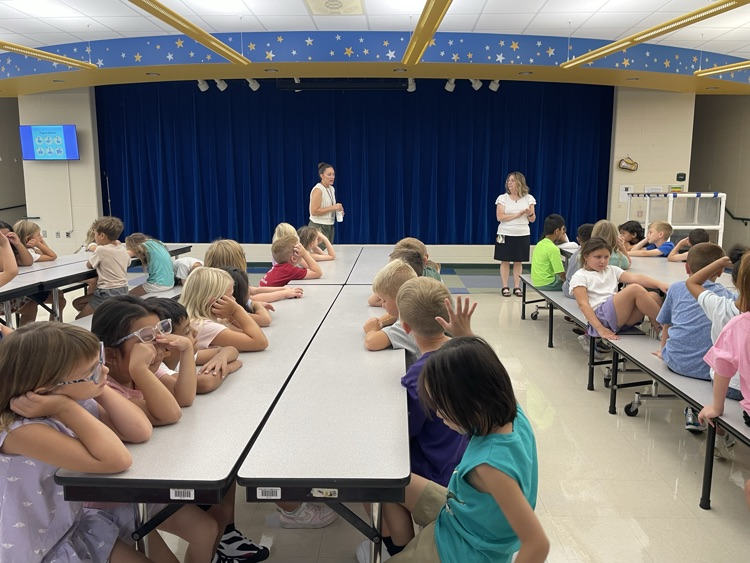 students sitting at lunch tables listening to our school counselors. 