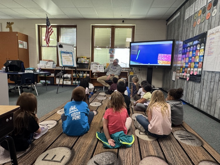 students listening to a book being read.