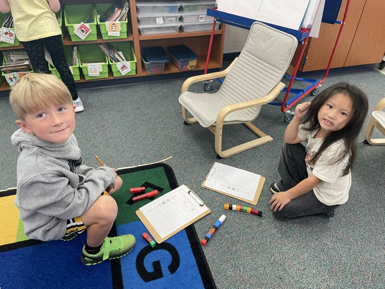 a boy and girl first grader measuring with cubes