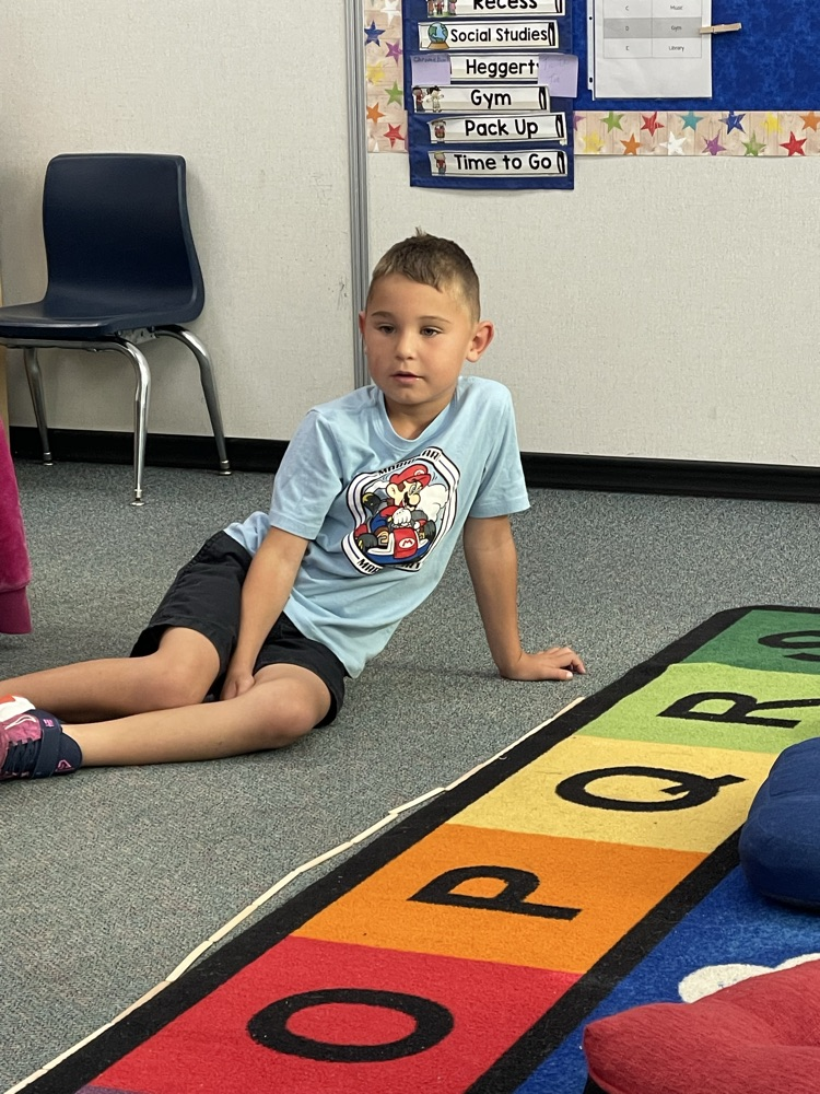a boy counting popsicle sticks to measure the rug