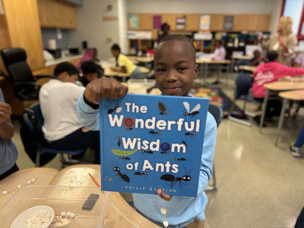 Studemt holding up a book with the title "the wonderful wisdom of ants"