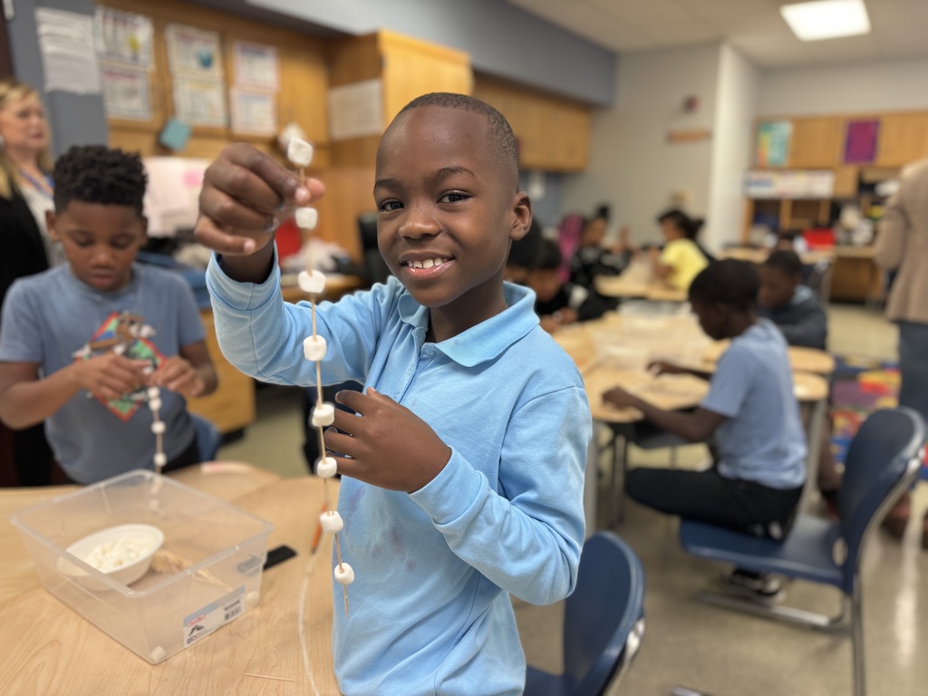 Students holding up a bridge that they made