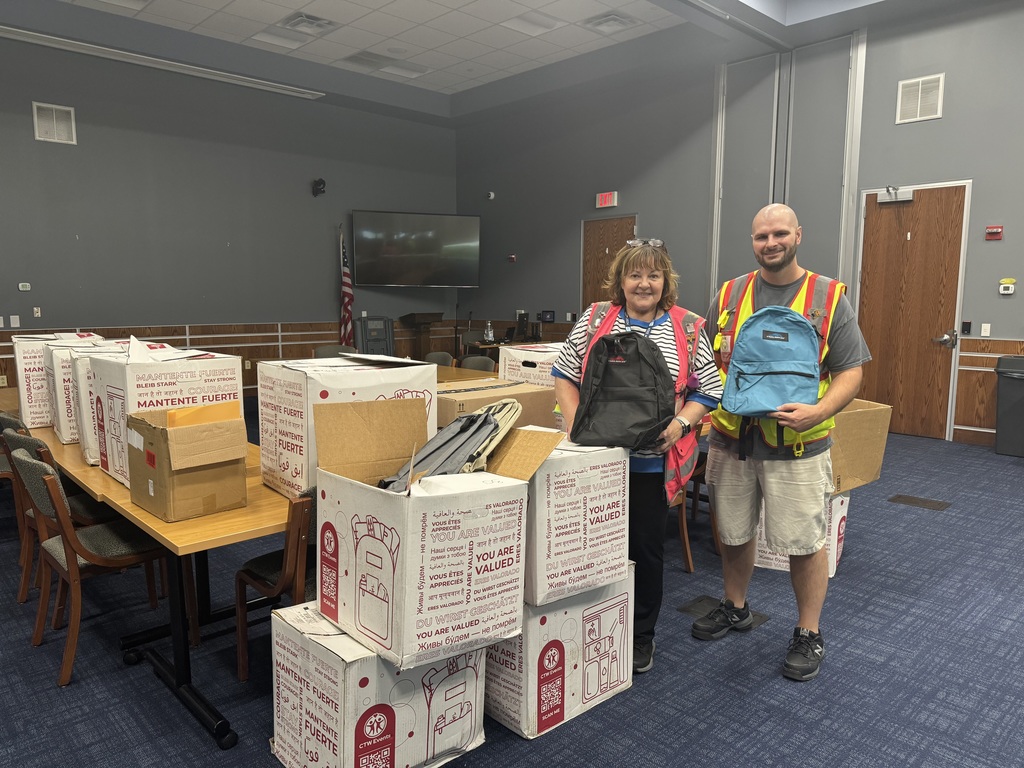 Two people holding up bookbags