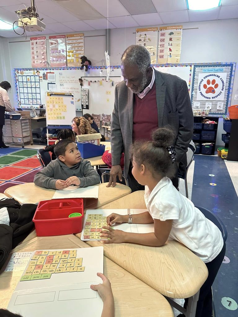 Guest in a PreK classroom looking at activities