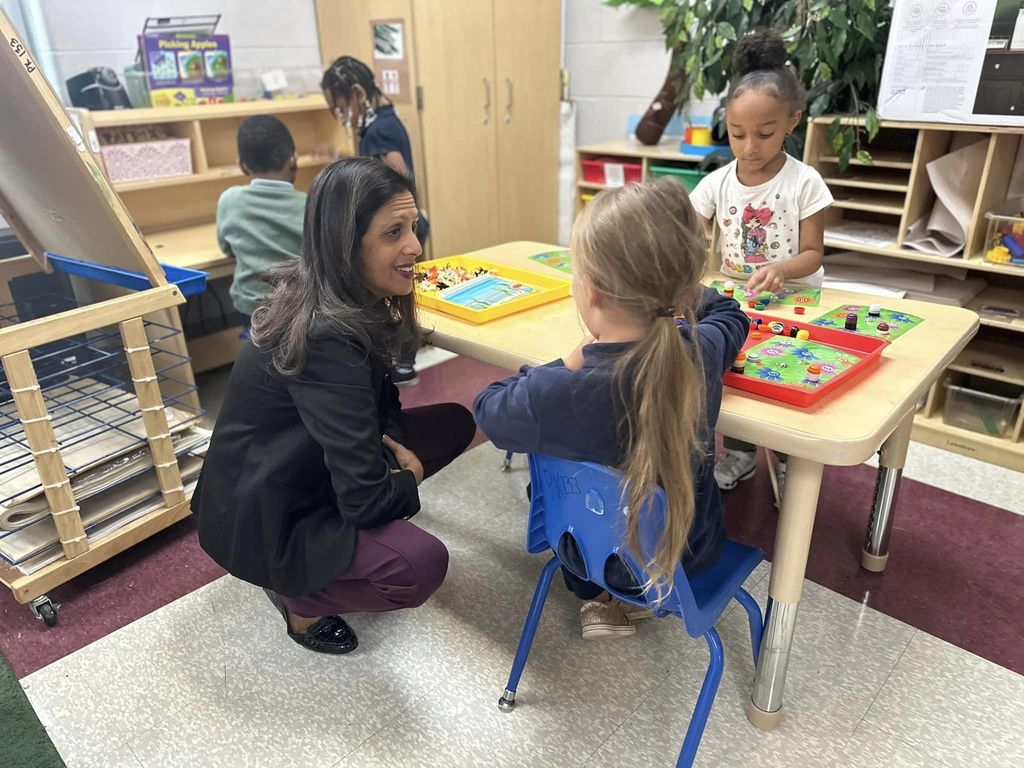 Guest in a PreK classroom looking at activities