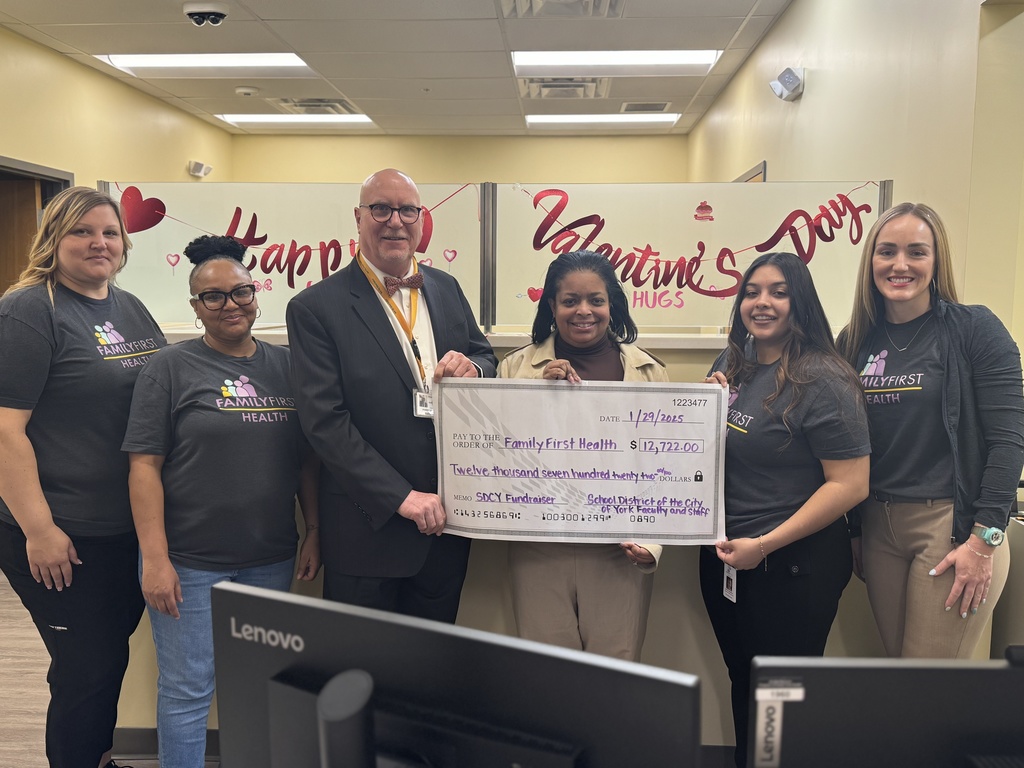 School district and family first health center staff holding a donation check