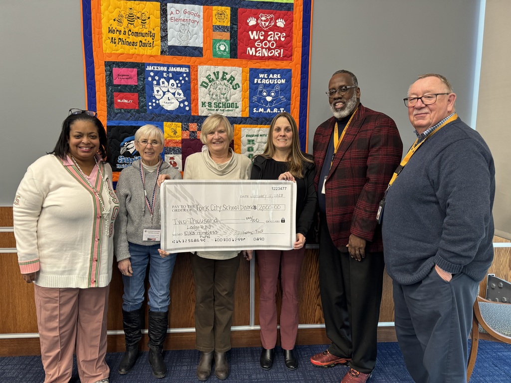 Group of people smiling and holding a check 