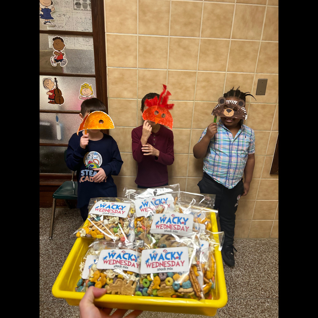 Group of students smiling and holding up masks with treats 