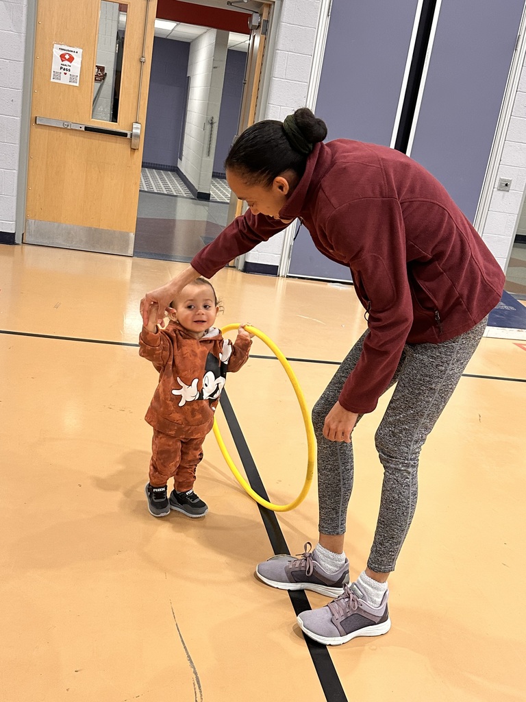 An adult and a toddler holding a hula hoop
