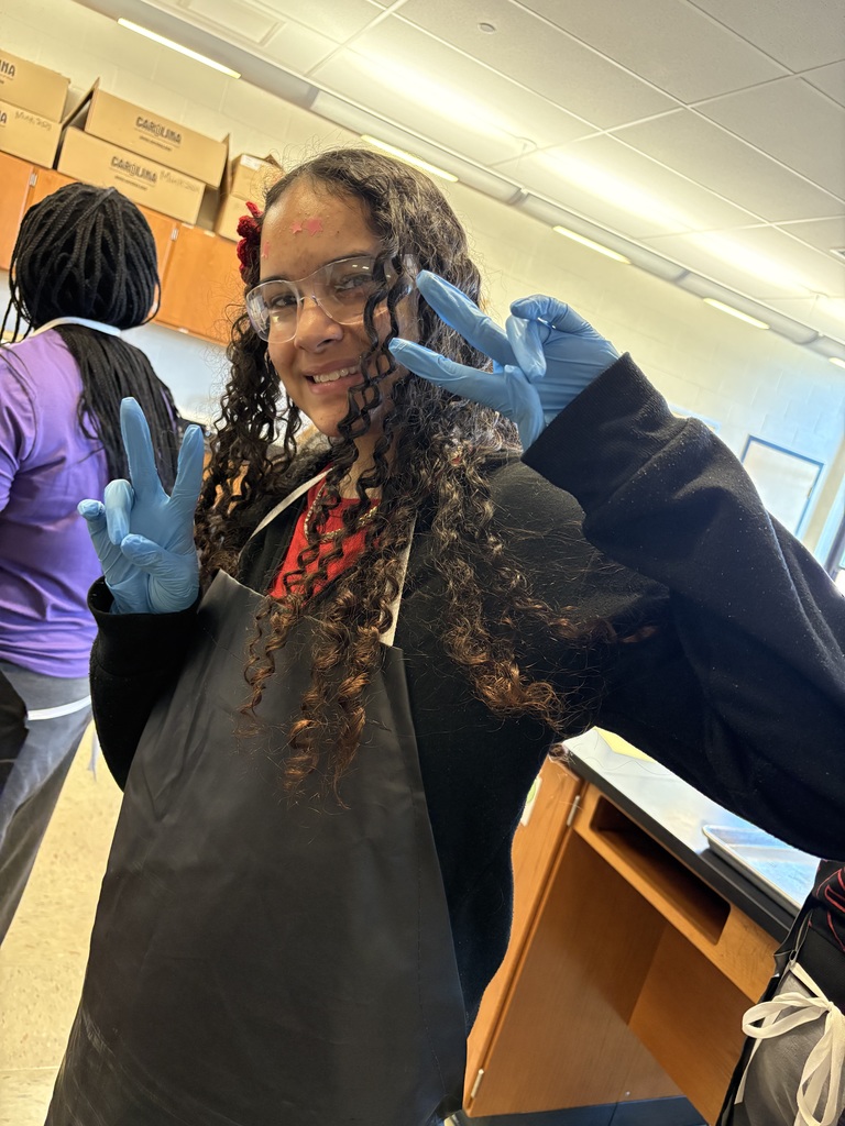 One student holding up two peace signs and smiling