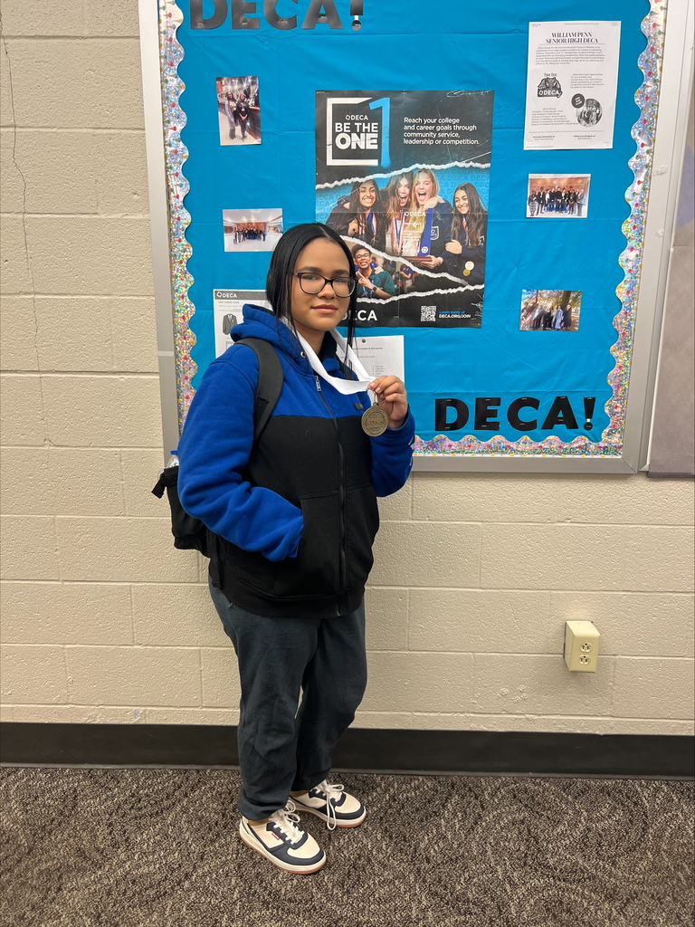 A student holding up a medal