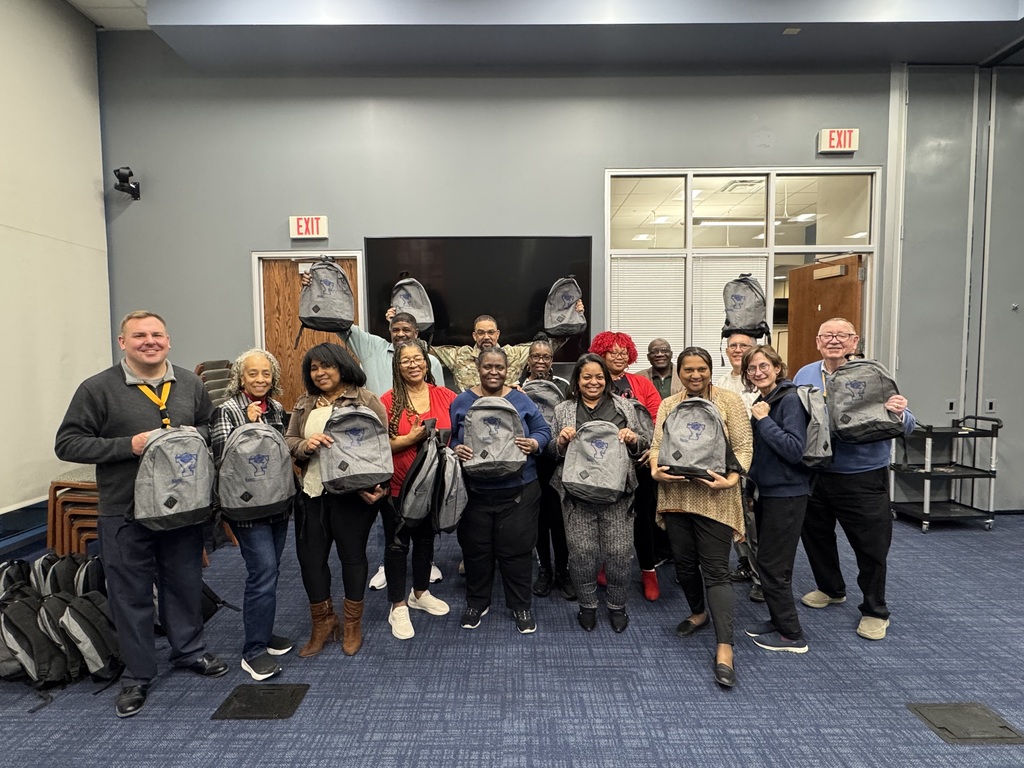 A group of people holding up bookbags