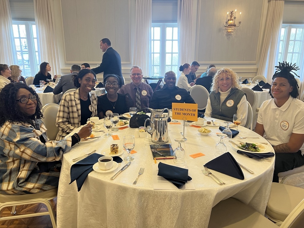 A group of people smiling and sitting at a table