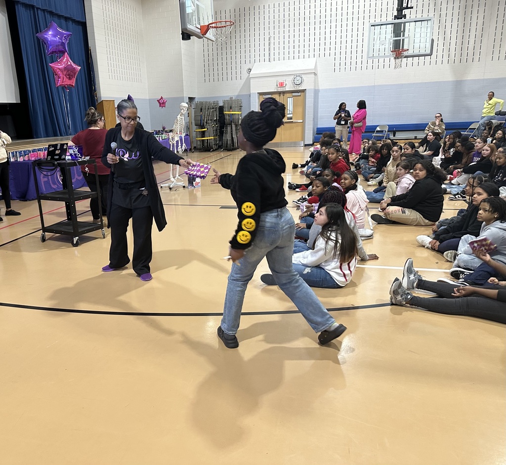 An adult giving a gift to a student