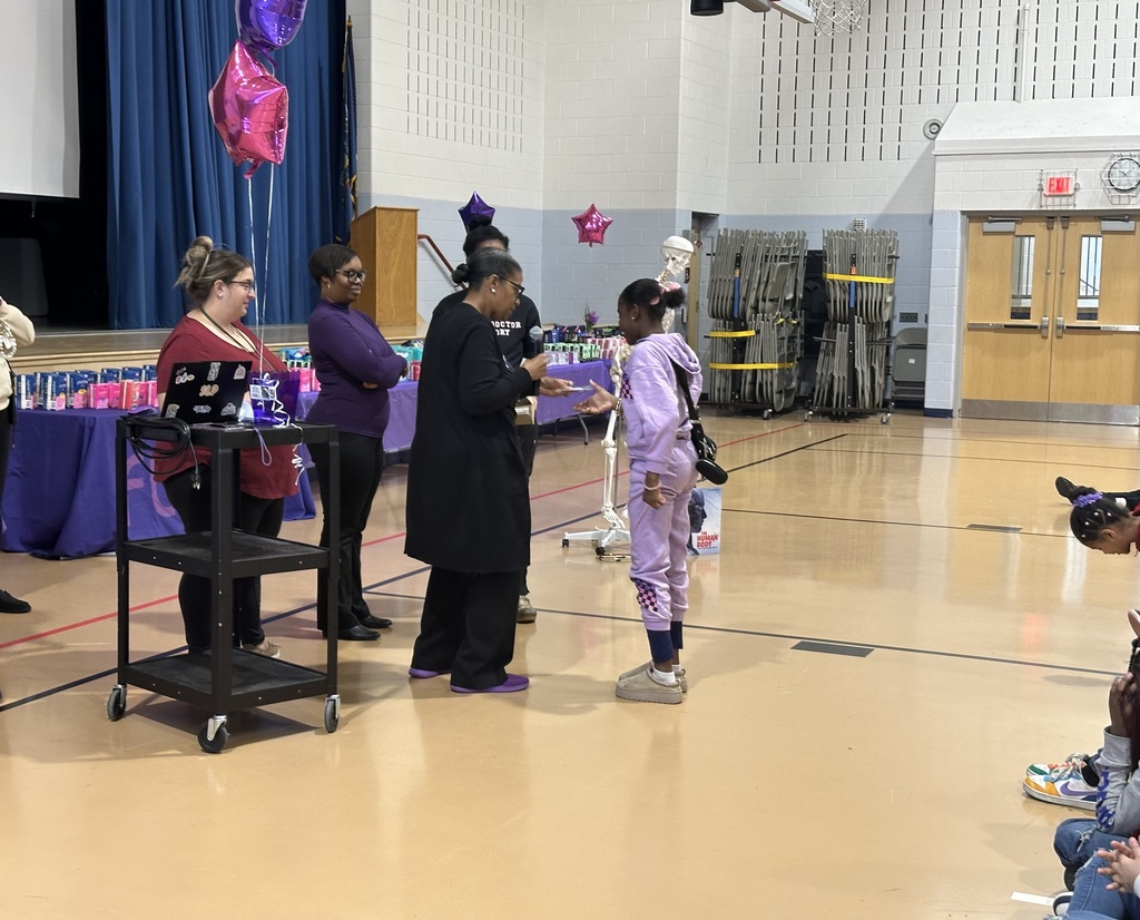 An adult giving a gift to a student