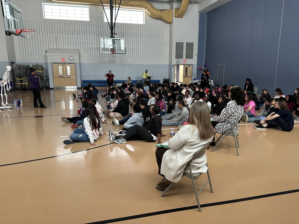 Group of students and adults sitting and listening to a presentation