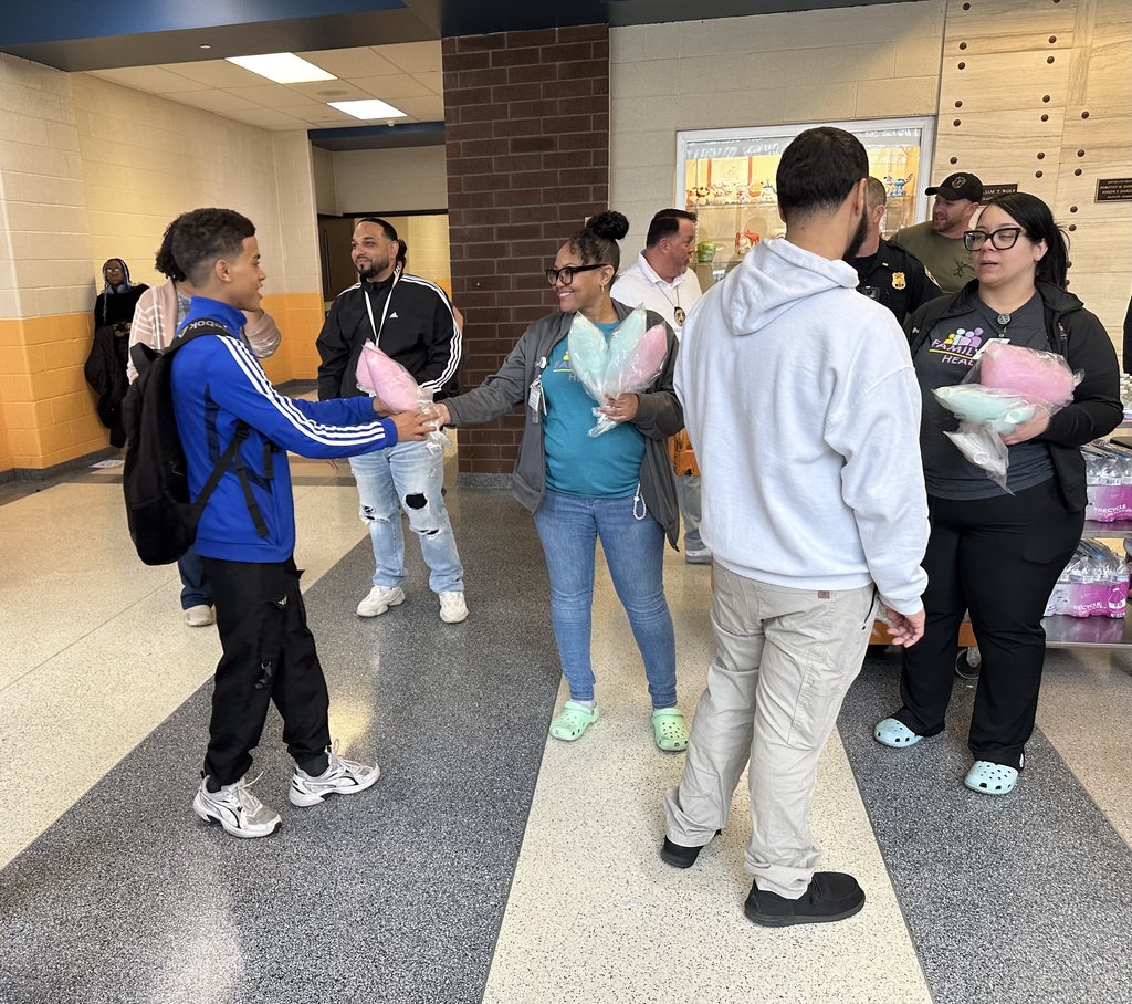 Adult handing cotton candy to a student