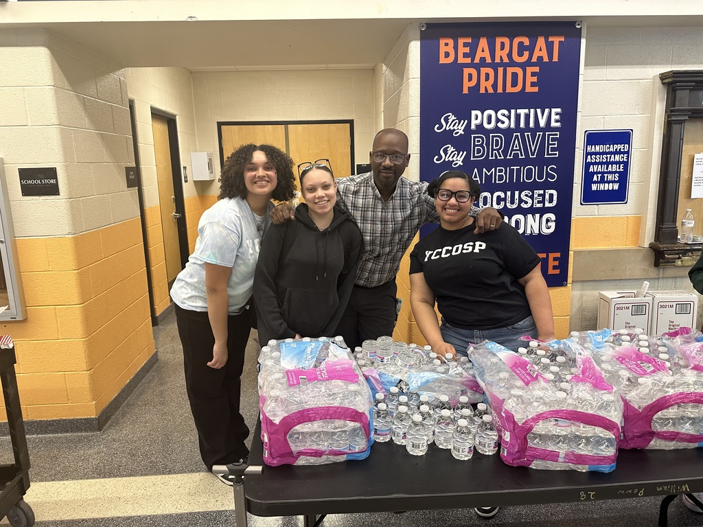 One adult and two students smiling