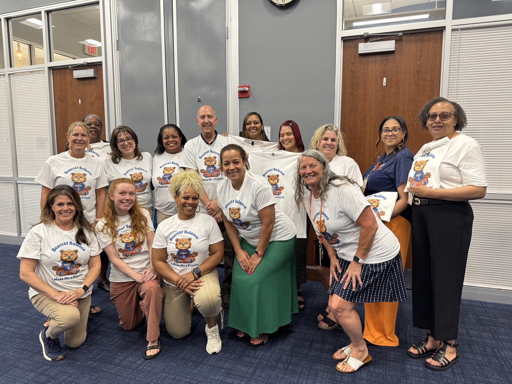 A group of people in matching Bearcat Balance shirts in the Board Room