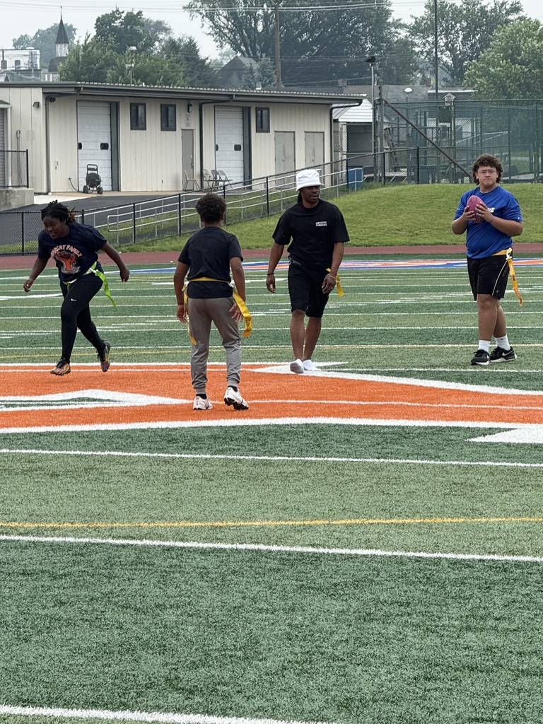 Four people playing flag football on a sports field