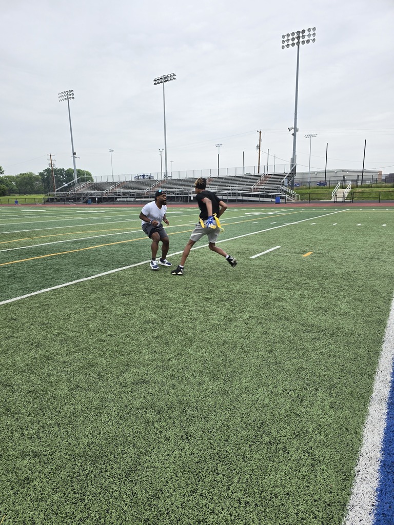 Two people playing against each other in flag football on a sports field 
