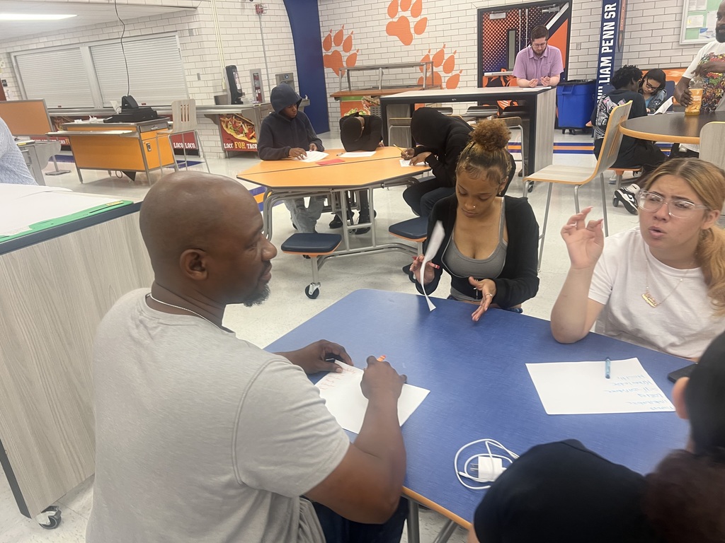 A group of students engaged in an activity in a high school cafeteria.