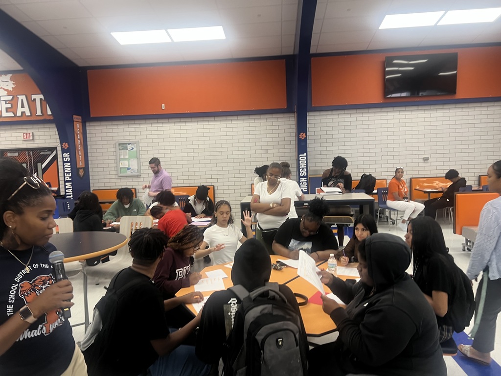 A group of students engaged in an activity in a high school cafeteria.