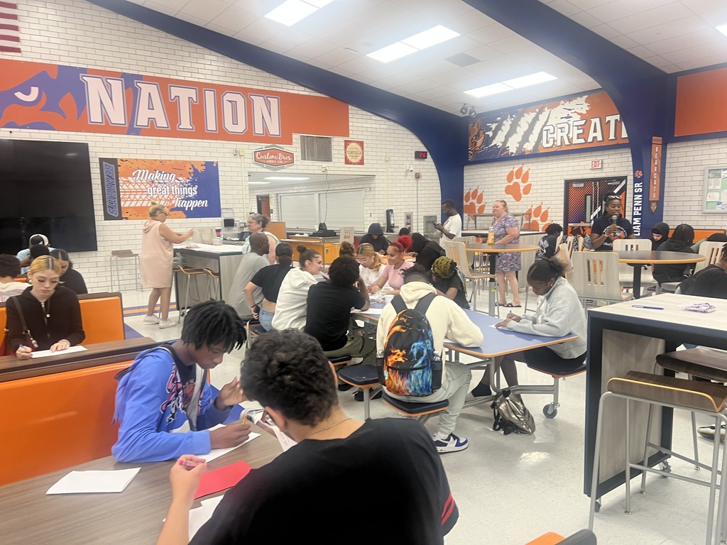 A group of students engaged in an activity in a high school cafeteria.