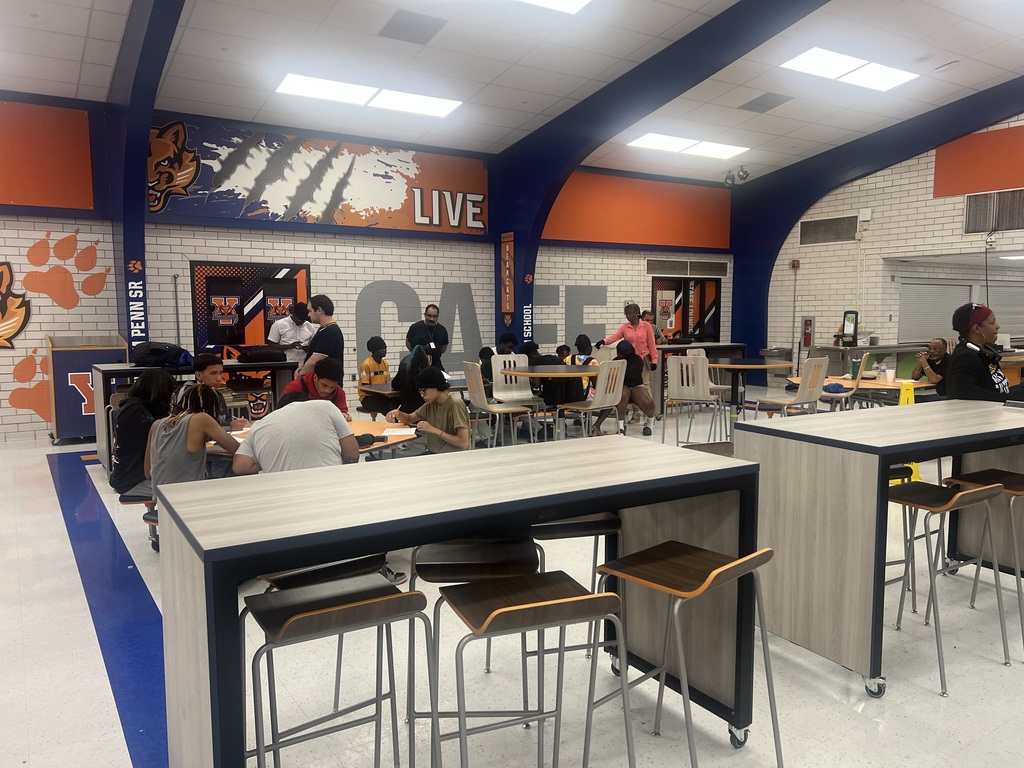 A group of students engaged in an activity in a high school cafeteria.
