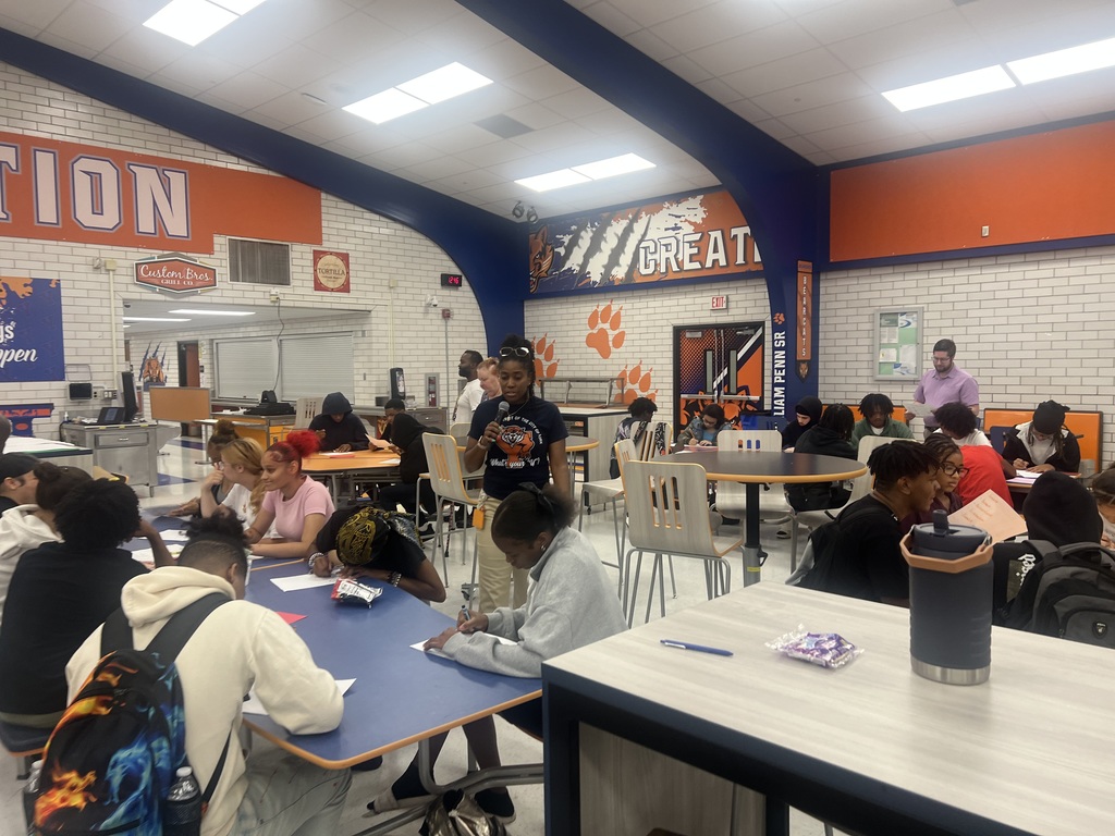 A group of students engaged in an activity in a high school cafeteria.