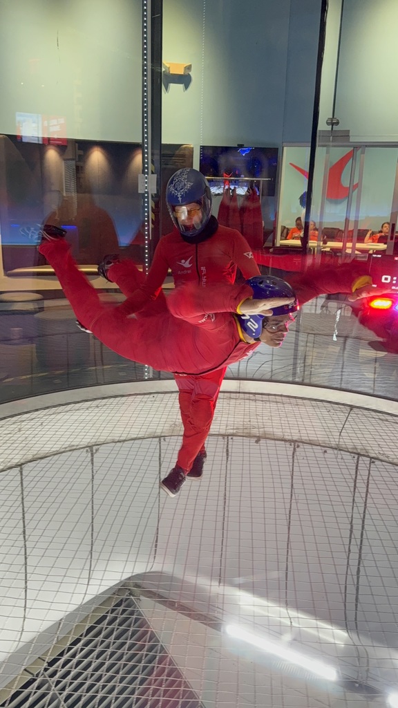 Student flying indoors at iFLY with instructor. 