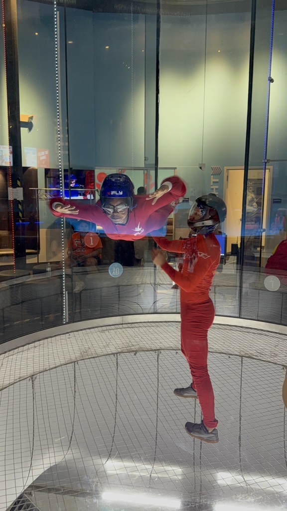 Student flying indoors at iFLY with instructor. 