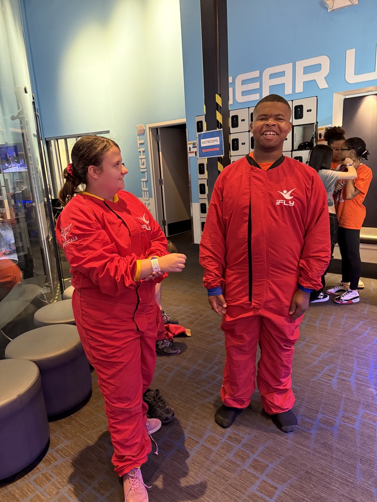 One student is smiling while looking at another student who is also smiling.