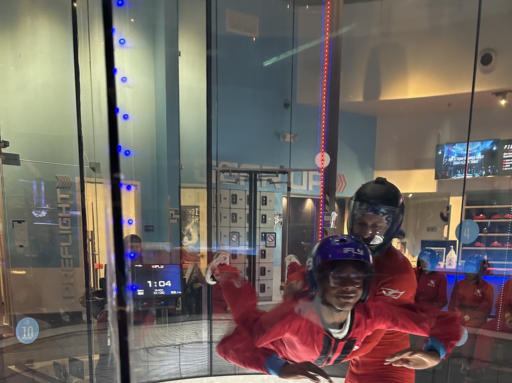 Student flying indoors at iFLY with instructor.