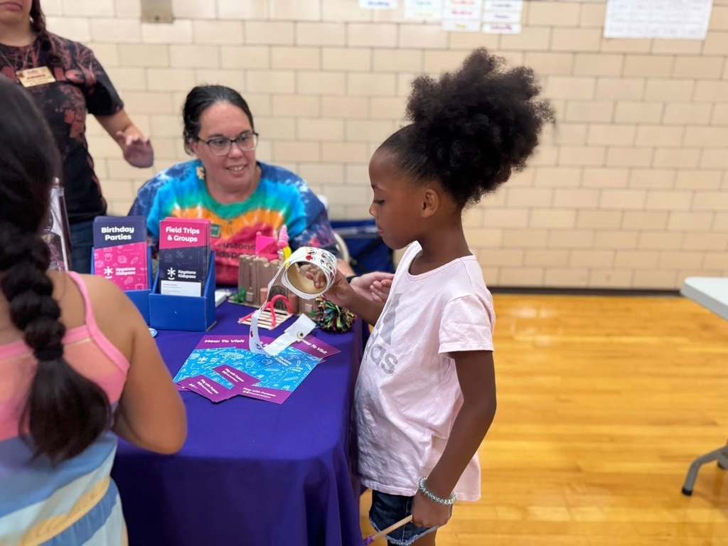 A young student grabbing a sticker at Devers PreK-8's Back to School Night.