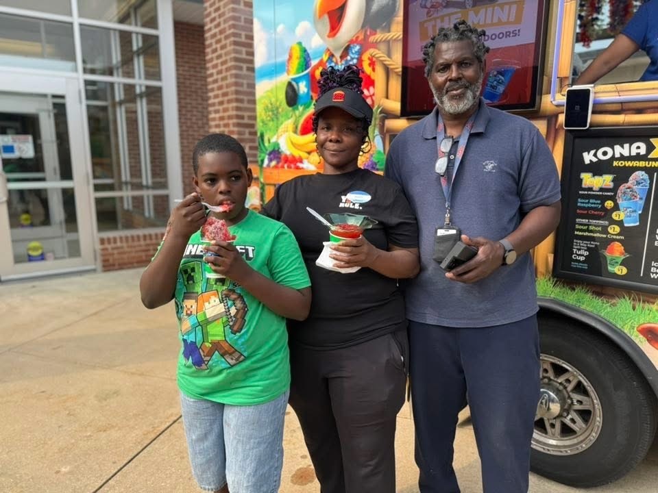 A family of three enjoying water ice at Goode PreK-8's Back to School Night.