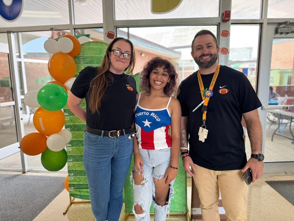 Goode Principal and Assistant Principal, Dr. Koerner and Mr. Shiposh posing for a photo with a student in front of a backdrop.