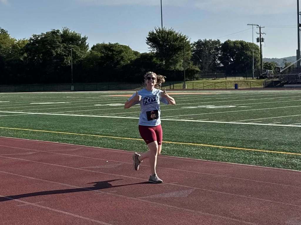 District staff member holding her thumbs up in the middle of participating in the School District of the City of York's 5K Run and Walk.