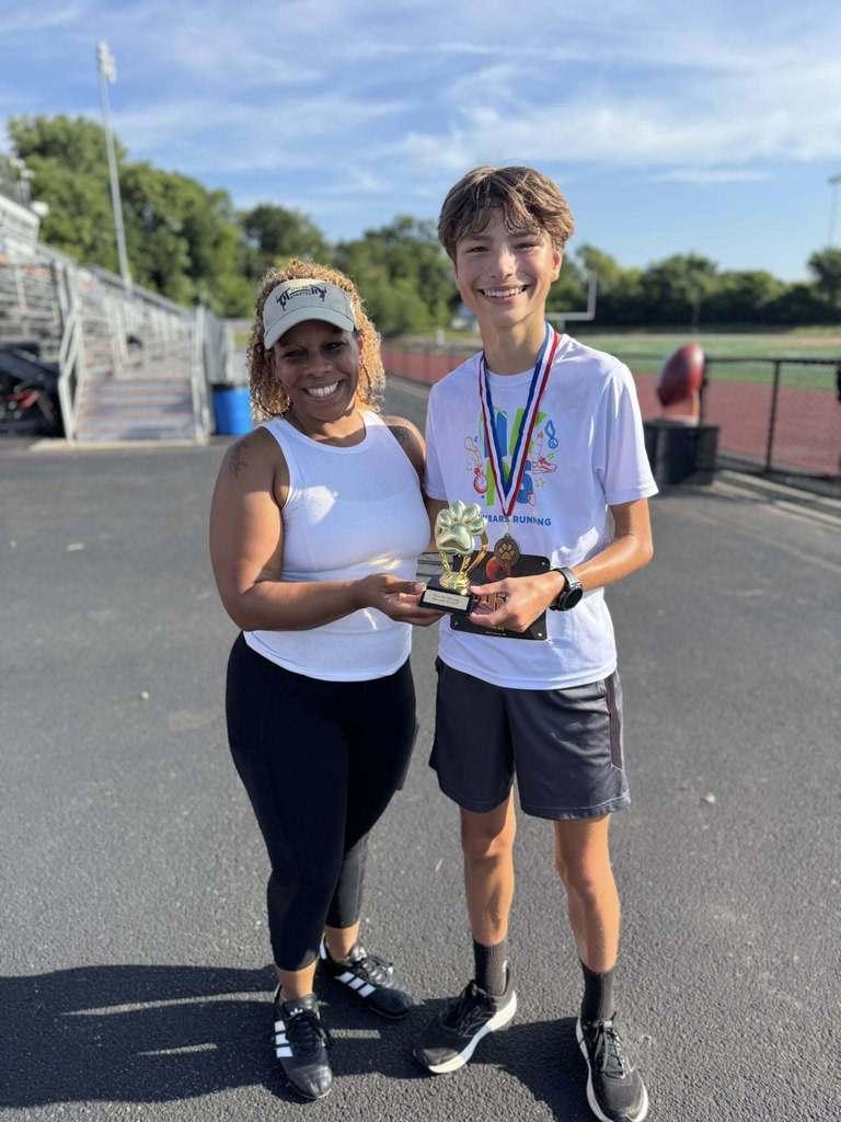 District staff member and a student holding up a trophy at the School District of the City of York's 5K Run and Walk.