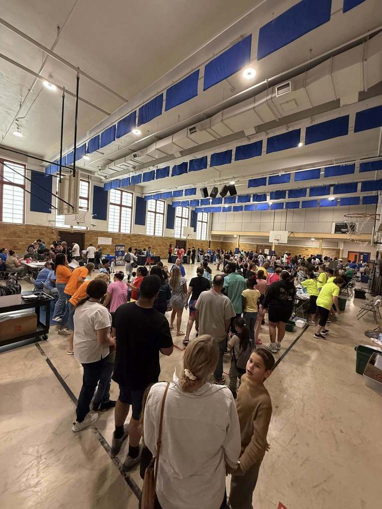 A crowded gymnasium filled with people participating at Davis PreK-8's Back to School Night.