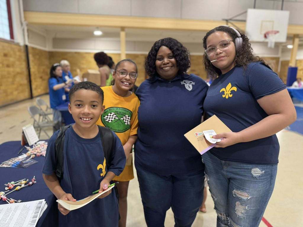 A School Board Member and three students posing together at Davis PreK-8's Back to School Night.