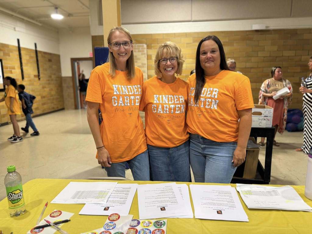 District staff members wearing Kindergarten shirts and posing together at Davis PreK-8's Back to School Night.