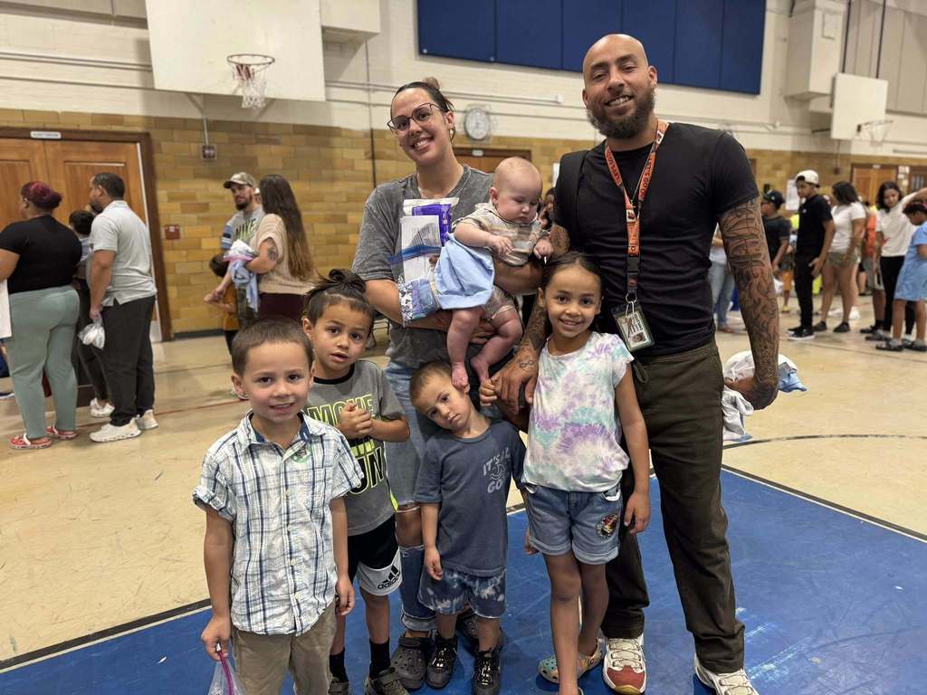 Two adults and 5 children posing together at Davis PreK-8's Back to School Night.