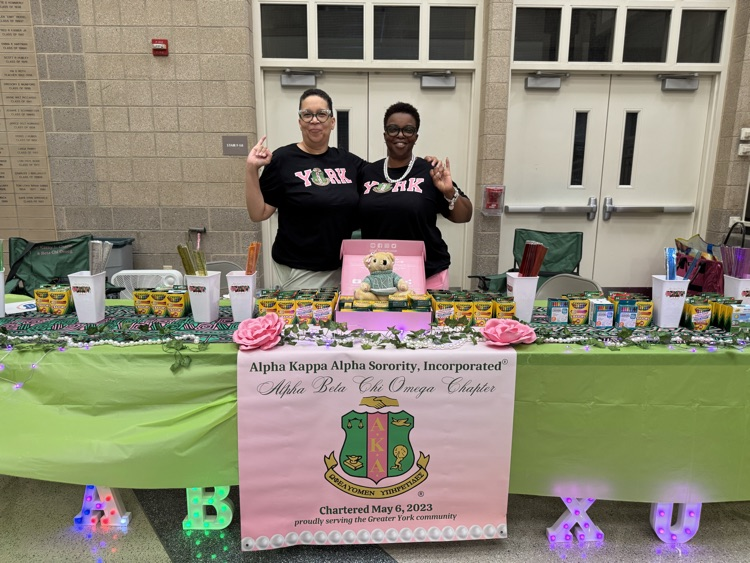 Two women holding up an AKA pose.