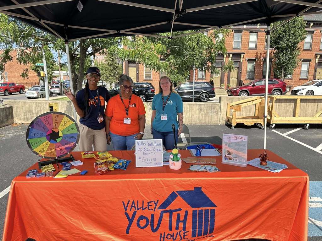 Community Partner at William Penn Senior High School's Back to School night, standing next to their table.
