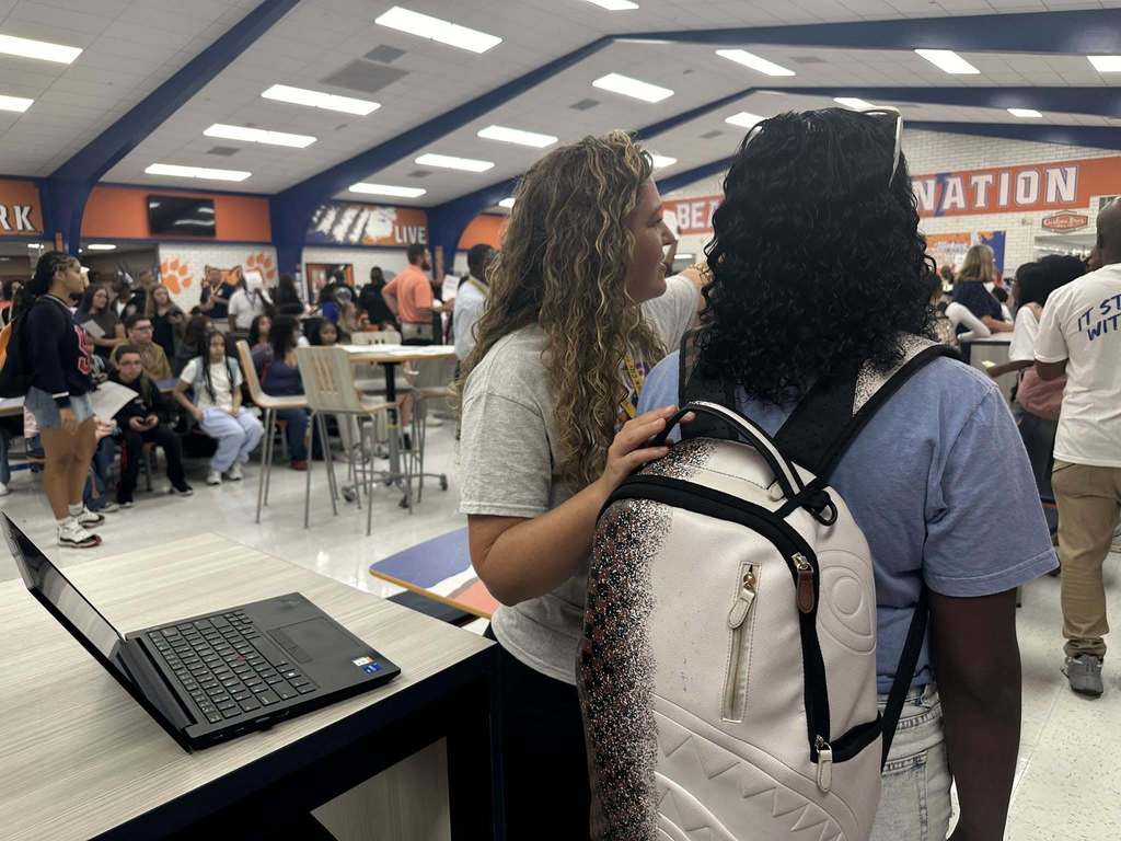 District staff member helping a student inside of William Penn Senior High School's cafeteria.