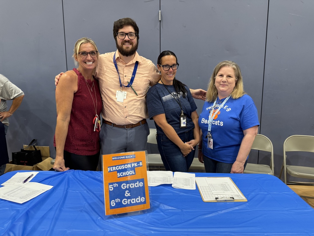 Four district staff members posing for a photo during Ferguson PreK-8's Back to School Night.