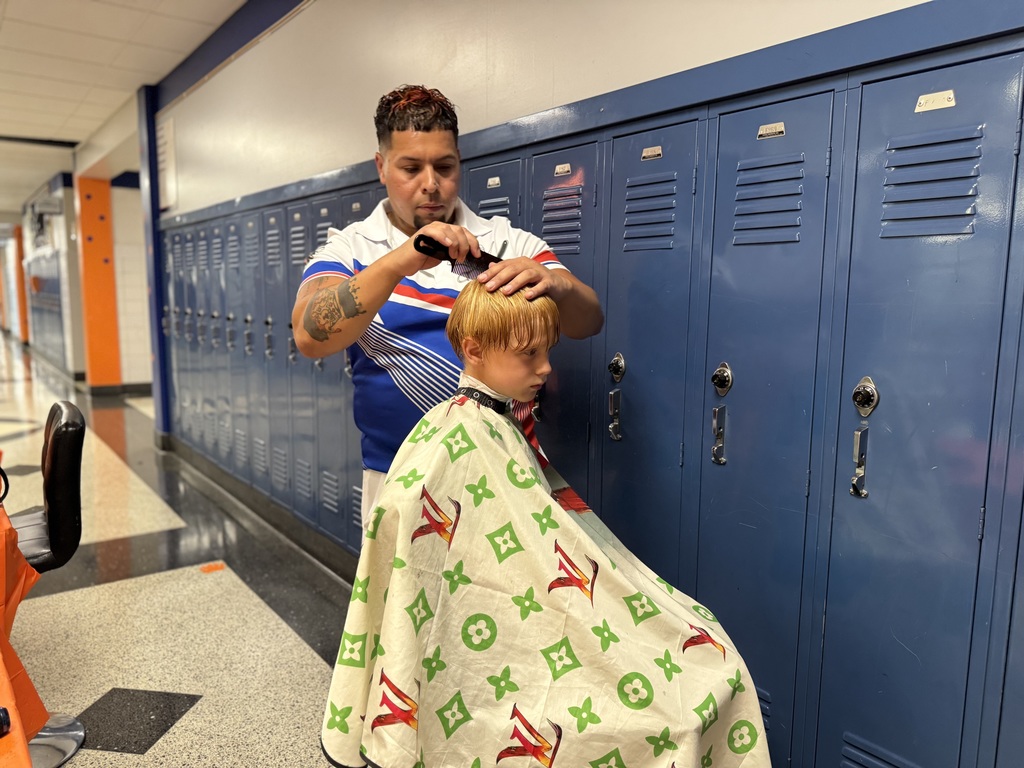A barber giving a student at Hannah Penn a haircut during their recent Back to School Night.