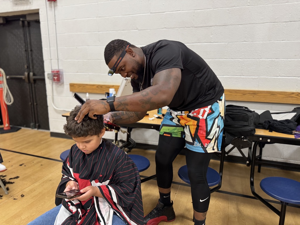 A barber giving a Jackson PreK-8 student a haircut.